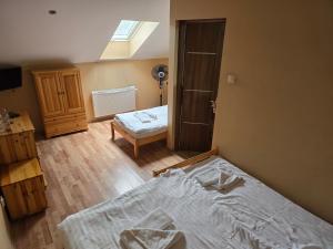 a room with a bed and a bedroom with a window at Agroturystyka Chelosiowy Dworek in Piekoszów