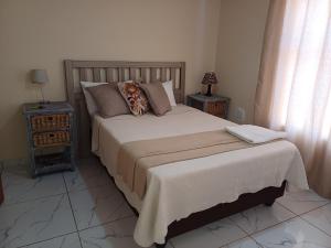 a bedroom with a large bed and two night stands at Sheeroh's Place in Burgersfort