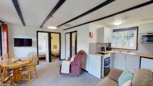 a kitchen and a living room with a table and chairs at 14 Tudor Court, Tolroy Manor in Hayle +10 photos