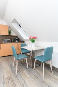 a kitchen with a table and chairs and a staircase at Haus Strandkorb FeWo Strandkob 8 in Bensersiel