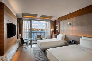 a hotel room with two beds and a view of the water at The Grand Tarabya Managed by Accor in Istanbul +37 photos