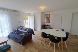 a living room with a bed and a table with chairs at Petite maison, jardin privé clos, classée 3 étoiles in Acquigny