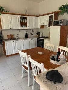 a kitchen with a wooden table and white cabinets at Casa Ohana in Serramanna +6 photos