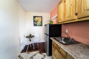 a kitchen with a sink and a black refrigerator at Skyline Suites 2 Queen bedroom - perfect for a couples getaway! condo in Montego Bay
