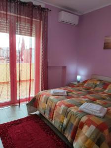 a bedroom with a bed and a large window at Barocco salentino Home in Lecce