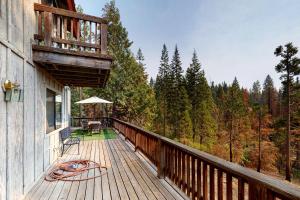 a balcony of a house with a view of a forest at Forest Falls in Shaver Lake
