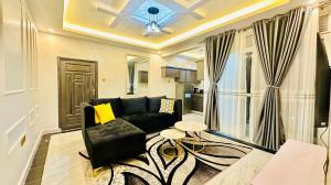 a living room with a black couch and a table at Serenity luxury Naalya in Kampala