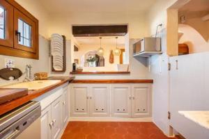 a kitchen with white cabinets and a sink at Casa Senrramada in Illes Balears +25 photos
