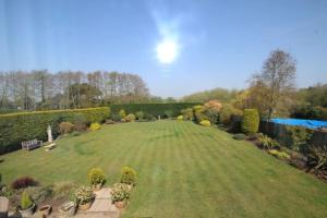 ein großer Rasenplatz mit Pool im Garten in der Unterkunft Wildwoods - just moments from the beach! in Worth