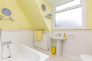 ein Badezimmer mit einer weißen Badewanne und einem Waschbecken in der Unterkunft Wildwoods - just moments from the beach! in Worth + 7 Fotos