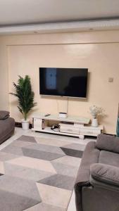 内罗毕Warm and Cosy 2 bedroom的客厅墙上有一台平板电视