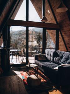 a living room with a couch and a large window at УЛІС Ворохта in Ilʼtsya Gurny