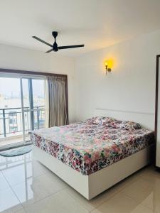 a bedroom with a bed and a window and a ceiling fan at 6Floor in society Ecity ph2 Near TCS Tech Mahindra in Bengaluru