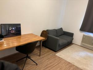 a room with a desk and a couch and a table at 2 Zimmer Wohnung an der Isar in Munich
