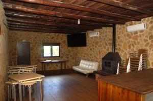 salon z piecem opalanym drewnem i krzesłami w obiekcie Casa rural Dalia w mieście Sierra de Fuentes