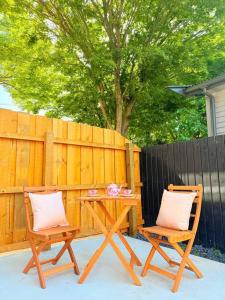 two chairs sitting next to a table and a fence at Tranquil 3 Bed Minutes To CBD And Arena, Sleeps 7 in Christchurch