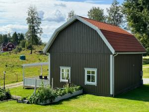 a large green shed with a red roof at Ny lägenhet i Vesene in Ljung