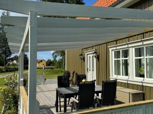 a patio with a table and chairs on a deck at Ny lägenhet i Vesene in Ljung +14 photos