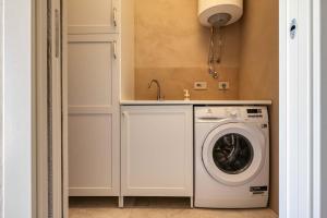 a laundry room with a washing machine and a sink at Villa Carrubbu in Favignana