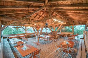 a restaurant with wooden tables and chairs on a wooden deck at Breitenberger Hof "inklusive Frühstück" in Breitenberg
