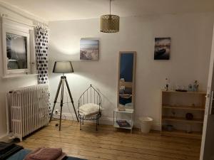 Camera con letto a tre piazze, sedia e lampada di Maison Corneille proche de Lille a Hem