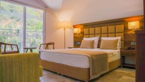 een slaapkamer met een groot bed en een groot raam bij Ölüdeniz Turquoise Hotel - All Inclusive in Oludeniz