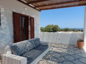 a porch with a couch on a patio at Beach front Villa Pasithea in Monolithos