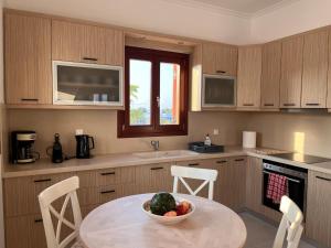a kitchen with a table with a bowl of fruit on it at Beach front Villa Pasithea in Monolithos +11 photos