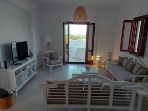 a living room with a couch and a tv at Beach front Villa Pasithea in Monolithos