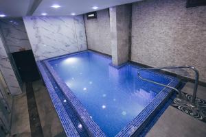 a swimming pool in a building with blue water at Royal Mersin Otel in Mersin
