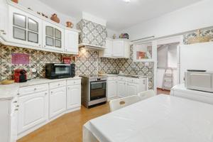 eine Küche mit weißen Schränken und einer weißen Arbeitsplatte in der Unterkunft Elegant Vintage House with barbecue in Cascais