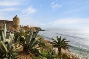 Blick auf das Meer und ein Schloss auf einer Klippe in der Unterkunft Elegant Vintage House with barbecue in Cascais