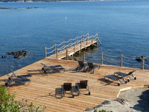 a wooden dock with chairs and a table and water at U Paviddonu in Porto-Vecchio