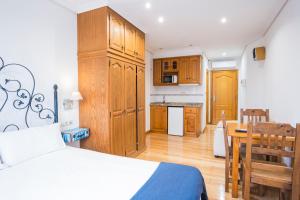 a bedroom with a bed and a kitchen with a table at InsideHome Porta do Sol in Vigo