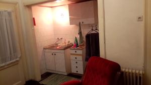 Una pequeña cocina con un fregadero y una silla roja. en Terazije Beograd, en Belgrado 13 fotos más