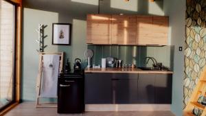 a kitchen with a refrigerator and a counter top at Czas i Las Glamping in Sadek
