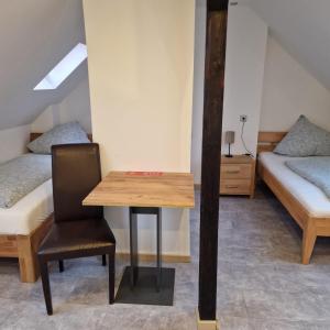 a room with two beds and a table and a chair at Balthasar Neumann Speiserei & Gästehaus - Zentrum Brühl -E-Ladestation, nähe Phantasialand in Brühl