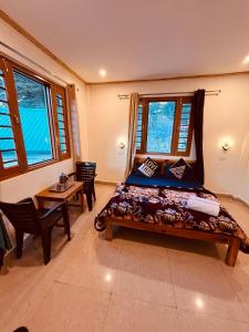 HarsilSkyard Hostel Harshil Valley的卧室配有床、桌子和窗户。