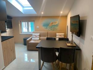 uma sala de estar com uma mesa e um sofá em Eco Sea Residence em Piran