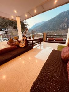 HarsilSkyard Hostel Harshil Valley的客厅配有吉他(位于地板上)