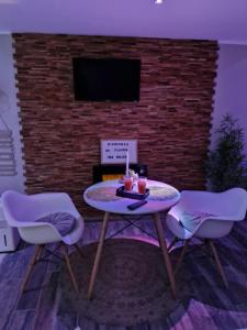 a living room with a table and two chairs at Studio avec jacuzzi , terrasse amenagée et wifi à Westrehem in Westrehem