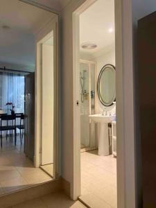 罗金汉姆Cosy, private guest house with pool and private parking的带水槽和镜子的白色浴室