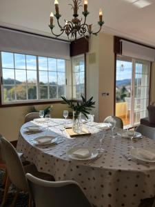 a dining room with a table with chairs and a chandelier at Casa Afouteza en Aldán in Piñeiro