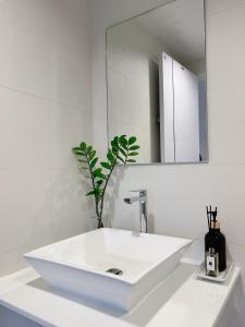 a white bathroom with a sink and a mirror at Komfy Quarters in Sathani Bang Khen +14 photos