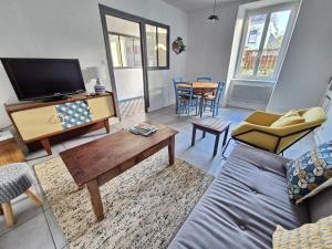 a living room with a couch and a tv at 729-Maison de pecheur a 150m de la plage in Plouhinec
