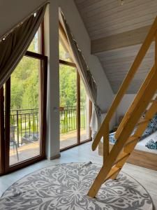 a room with a staircase and large windows at cabana din padure in Finiş