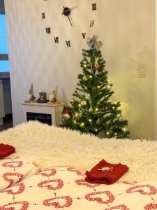un arbre de Noël dans une chambre avec un lit et un Noël dans l'établissement Rovaniemi City Centre Apartments, à Rovaniemi