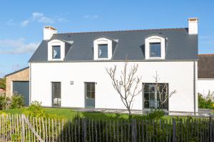 une maison blanche avec un toit noir dans l'établissement Ô Vagues de la Torche à 300m plage, à Penmarcʼh