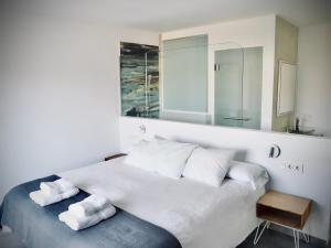 Un dormitorio con una gran cama blanca con dos toallas. en Casa rural Atalanta de la Vera, en Jaraíz de la Vera 46 fotos más