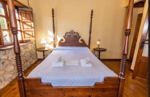 a bedroom with a wooden bed with two towels at Casa Horno in Robledo